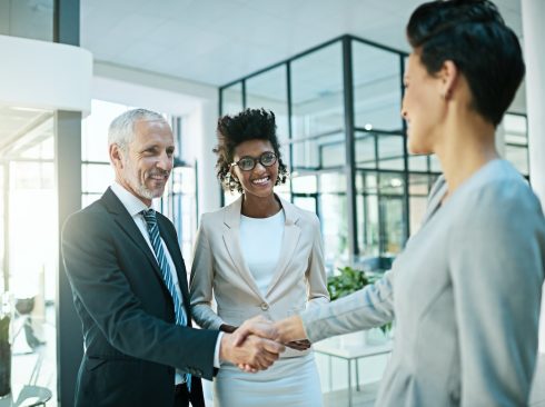 Shot of businesspeople shaking hands in an modern office.